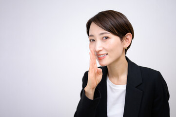 内緒でコッソリ話すスーツ姿の女性