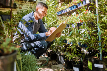Green, plants and man with checklist, inventory check at nursery, plant store and garden business....