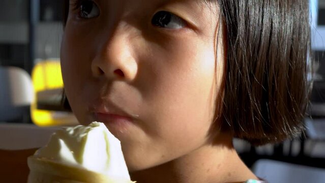 Close up little girl lick ice cream with tongue