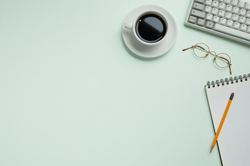 top view of pastel green desk with office stationary. copy space