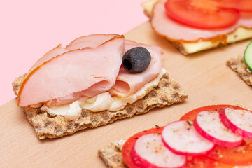 Different Whole Grain Crispbread with Ham, Tomato, Radish, Cucumber and Cheese. Easy Breakfast. Diet Food. Quick and Healthy Sandwiches. Crispbread with Tasty Filling. Healthy Dietary Snack