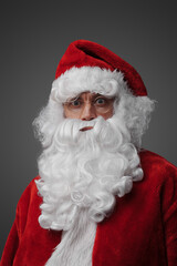 Headshot of santa claus with long beard and red costume isolated on grey.