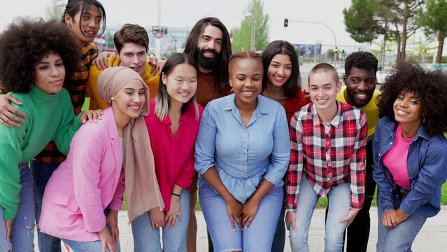 Cheerful group of happy multiracial friends having fun together outdoors in the city park. People enjoying a vacation. Friendship and diversity concept.
