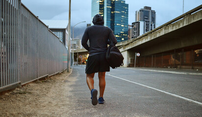 Fitness, black man and walking on city street after running, exercise and gym workout with a hoodie...