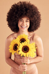 Beauty, skincare and black woman with sunflower, smile and natural hair on a studio background for...