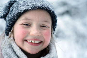 The girl's satisfied face in the winter. Smile. Red cheeks in the cold