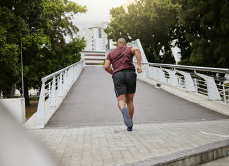 Fitness, exercise or black man running on bridge in city, street or road for wellness, cardio...