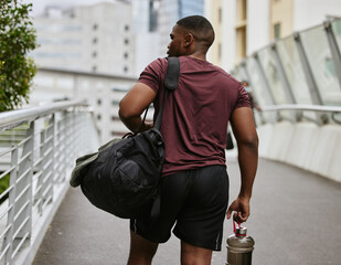 Black man, back or fitness bag on city bridge, road or street with workout gear, training water...