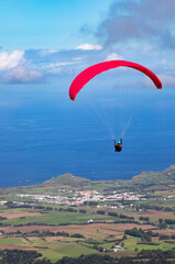 Paragleiter nach dem Start vom Pico Barrosa mit Blick über die Insel Sao Miguel, Azoren, Portugal,