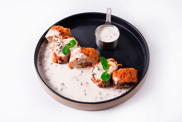 chicken meat rolls with stuffing and sauce on a white background