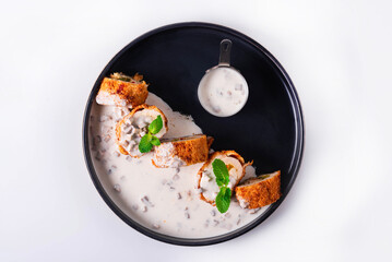 chicken meat rolls with stuffing and sauce on a white background