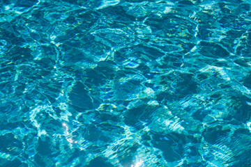 Water background, ripple waves. Blue swiming pool pattern. Sea surface. Water in swimming pool with sun reflection. Banner with copy space.