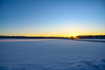 Sunrise a cold morning over field covered in snow