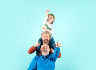 Grandfather father and son smiling and pointing finger against isolated background. Hand gestures...