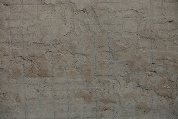 The rough gray texture of an old concrete wall. The surface of cement plaster with small cracks.