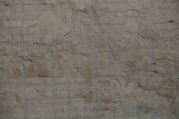 The rough gray texture of an old concrete wall. The surface of cement plaster with small cracks.