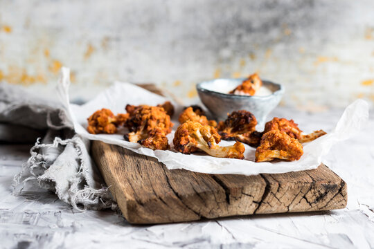 Freshly cooked barbecue cauliflower wings with sauce at cutting board