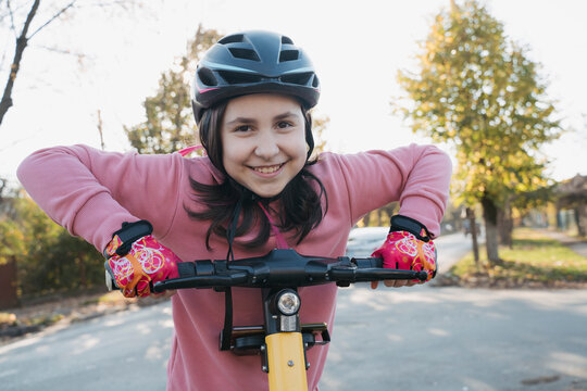 Happy girl with electric scooter on road