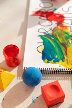 Colorful toy blocks and note pad covered in paint