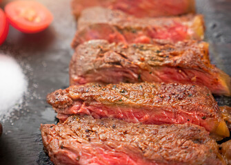 Sliced medium rare grilled Beef steak on wooden cutting board