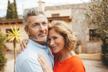 Happy mature woman hugging man at back yard