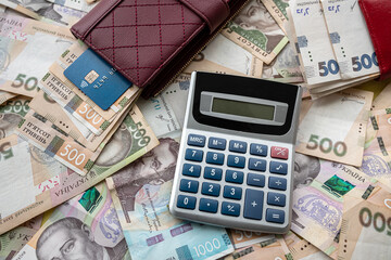 calculator with credit card on ukraine money in purse as financial background
