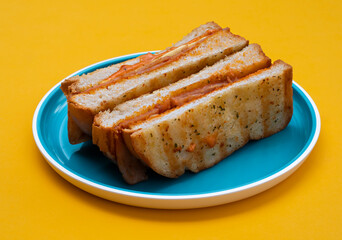 Bacon egg cheese sandwich toast with blue plate on yellow background.