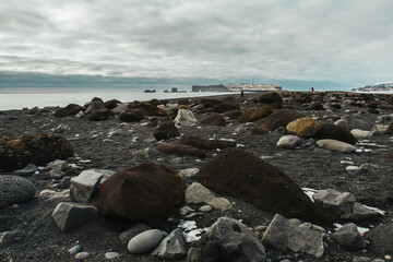 Beach with huge rocks landscape photo. Beautiful nature scenery photography with cloudy sky on background. Idyllic scene. High quality picture for wallpaper, travel blog, magazine, article
