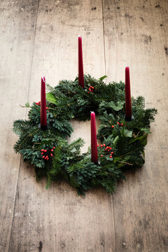 Studio shot of wreath made of spruce, juniper, ivy,rose hips and candles