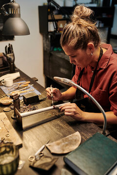 Craftswoman working at workbench in workshop