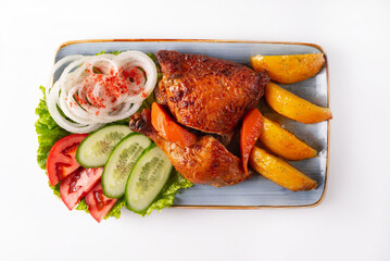 stewed chicken meat with potatoes and fresh tomatoes, cucumbers and onions on a white background