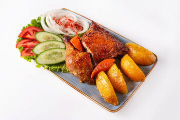 stewed chicken meat with potatoes and fresh tomatoes, cucumbers and onions on a white background