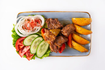 stewed meat with potatoes and fresh tomatoes, cucumbers and onions on a white background