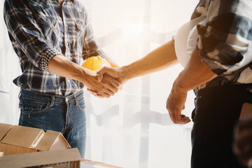 construction worker and contractor. Client shaking hands with team builder in renovation site.