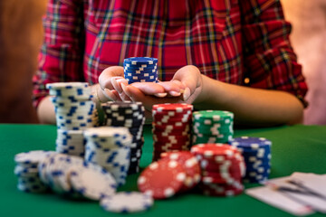cropped portrait of a young girl playing a men's game at a poker table.