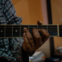 close up of hands on guitar strings