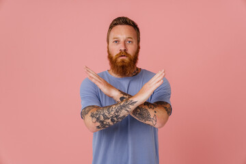 Ginger white man with beard posing and showing stop gesture