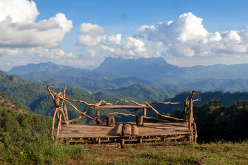 Fototapeta premium Wooden bench for view watching on fog mountain, hadubi camping views of Doi Luang Chiang Dao Chiang Mai Thailand.