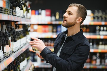 Man in a supermarket choosing a wine