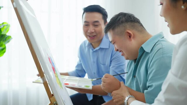 Asian happy family draw picture with young son in living room at home