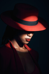 Fashion, red suit and woman in the dark for vintage clothes, retro and mafia aesthetic on a black studio background. Designer, mysterious and face of an elegant model with classy and fancy style - obrazy, fototapety, plakaty