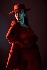 Fashion, red and edgy with a model black woman in studio on a dark background for trendy or...