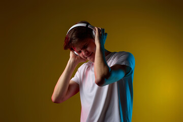 Young man listening to music with headphones