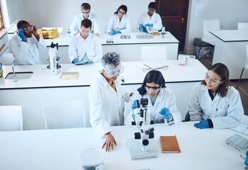 Science, university students and microscope in scientist lab for learning from mentor for medical...