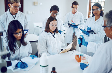 Science, students and education in a medical laboratory writing notes during scientist lecture or lesson with mentor or teacher. Medical men and women for training and learning in chemistry class