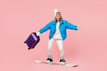 Snowboarder woman in blue suit goggles mask hat ski jacket hold bag snowboarding isolated on plain...