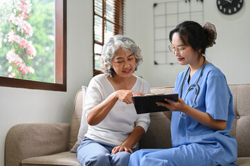 Fototapeta premium A happy and positive Asian old woman visiting doctor in the hospital office
