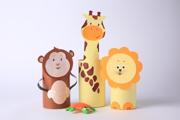 Obraz na płótnie Canvas Toy monkey, giraffe and lion made from toilet paper hubs with plasticine turtle on white background. Children's handmade ideas