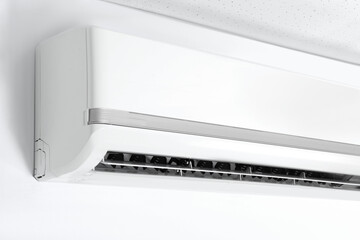 Modern air conditioner on white wall indoors, closeup