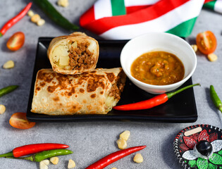 Mexican burrito with chorizo, potato and cheese served with sauce barracha